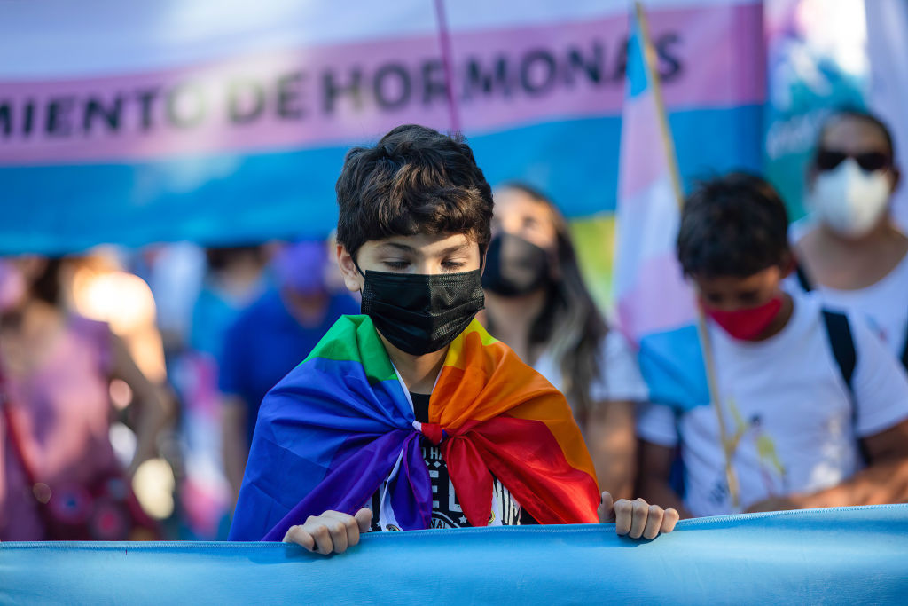A kid wrapped with a rainbow flag is seen during the demonstration