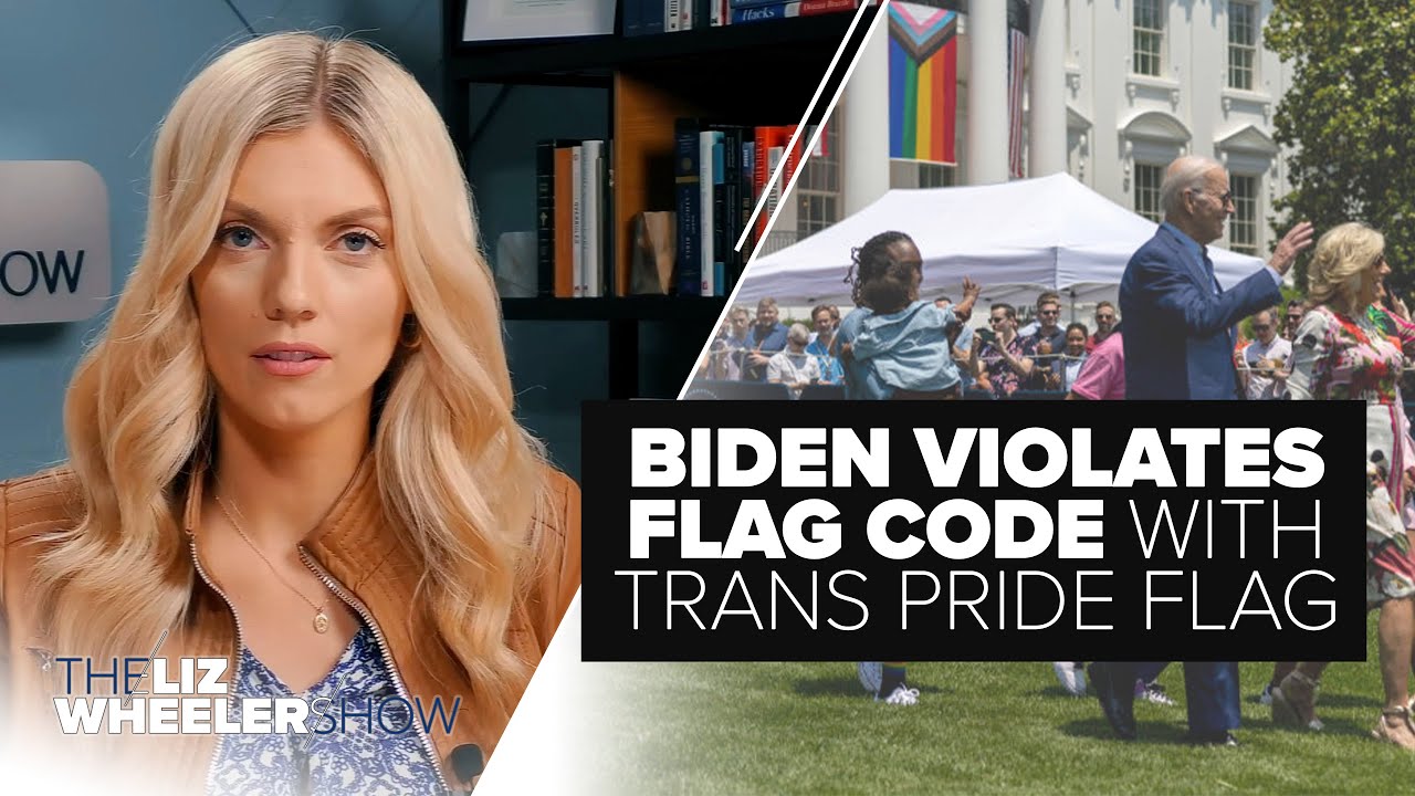 Joe Biden stands on the White House lawn, with a progress pride flag hanging in the background.
