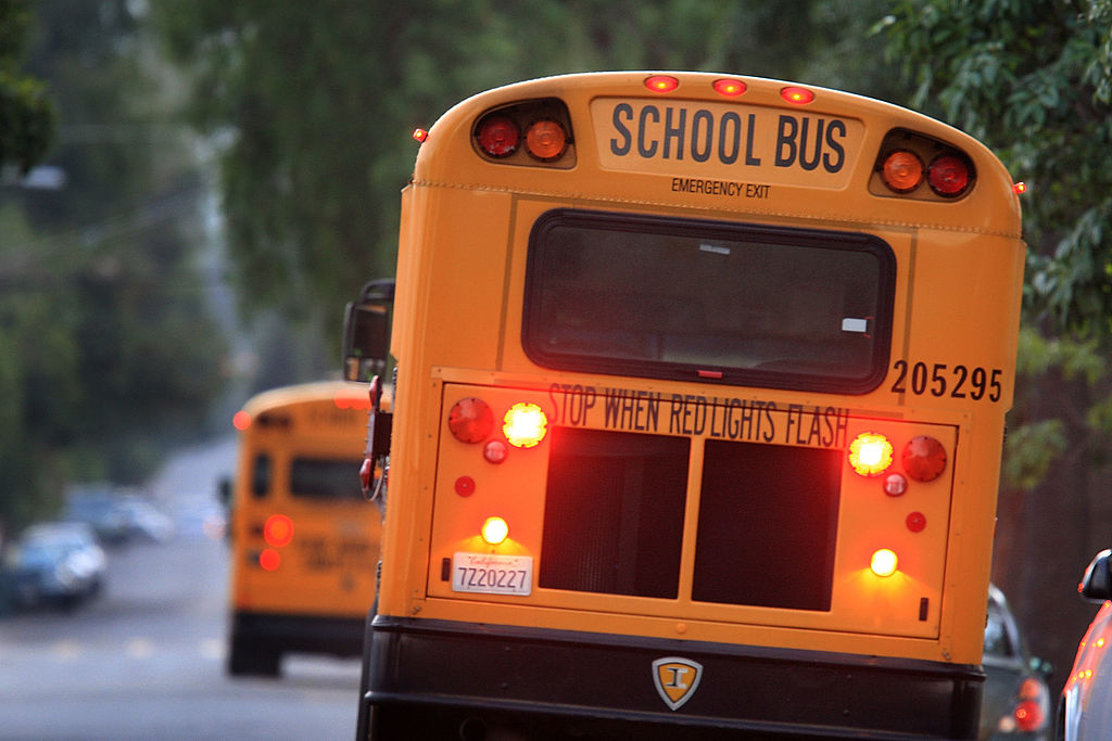 School buses drive down the road to pick up children before classes begin on October 10, 2008 in Pasadena, California.