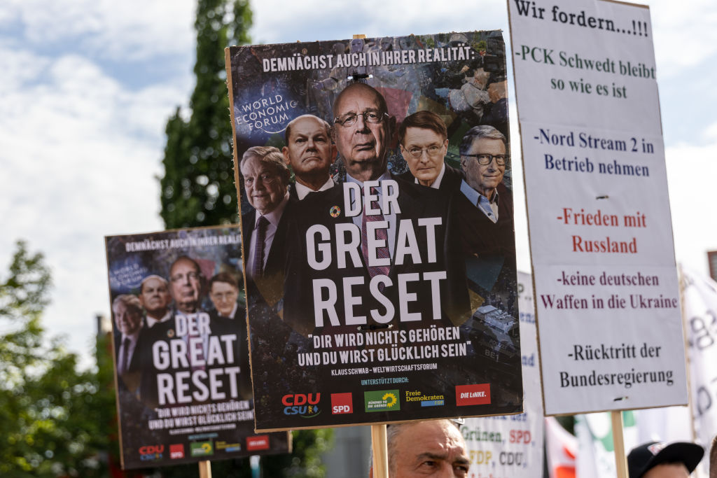 Protestors hoist flags combating Klaus Schwab's Great Reset and ESG