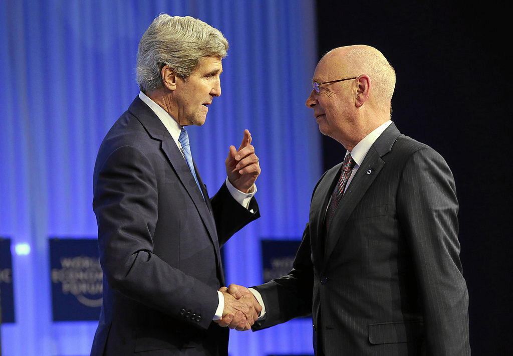 US Secretary of State, shakes hands with Klaus Schwab (R), Founder and Executive Chairman, World Economic Forum, during his 'Special Address' at the Annual Meeting 2014 of the World Economic Forum at the congress centre in Davos, January 24, 2014.