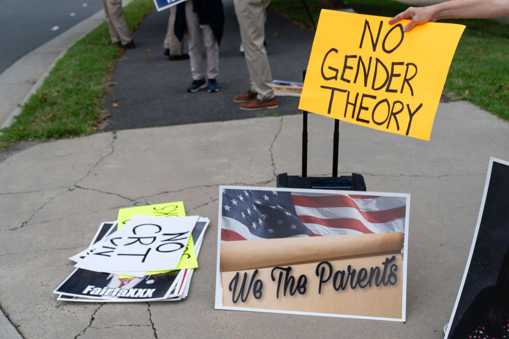 A woman holds a no gender theory sign outside of Luther Jackson Middle School in Falls Church, Va. on July 14, 2022. Groups have been protesting the school board over critical race theory, Family Life Education (FLE), and other issues.
