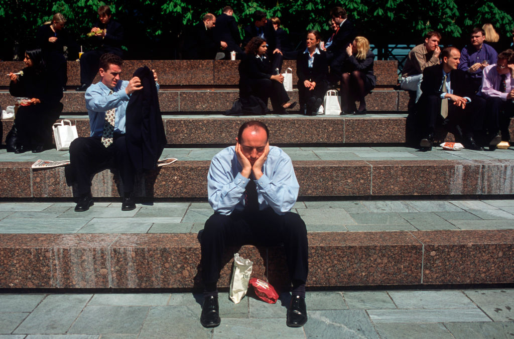 An exhausted office worker sleeps during lunch break in Broadgate in the City of London.