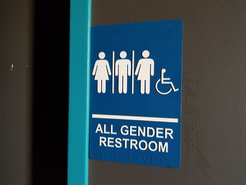 Close-up of sign for all gender restroom in Dublin, California, with male, female and gender-inclusive stick figure illustrations, March 13, 2019.