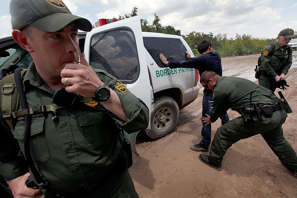 A Border Patrol agent searches an undocumented immigrant apprehended near the Mexican border on May 27, 2010 near McAllen, Texas.