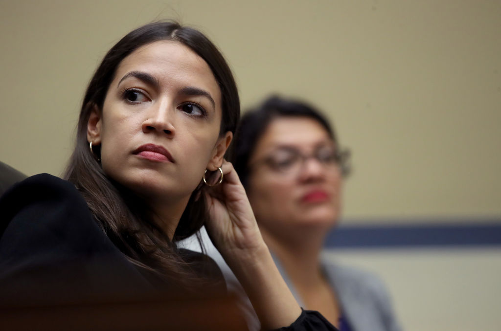Rep. Alexandria Ocasio-Cortez (L) (D-NY) and Rep. Rashida Tlaib (D-MI) listen to testimony from acting Homeland Security Secretary Kevin McAleenan while he testifies before the House Oversight and Reform Committee on July 18, 2019 in Washington, DC.