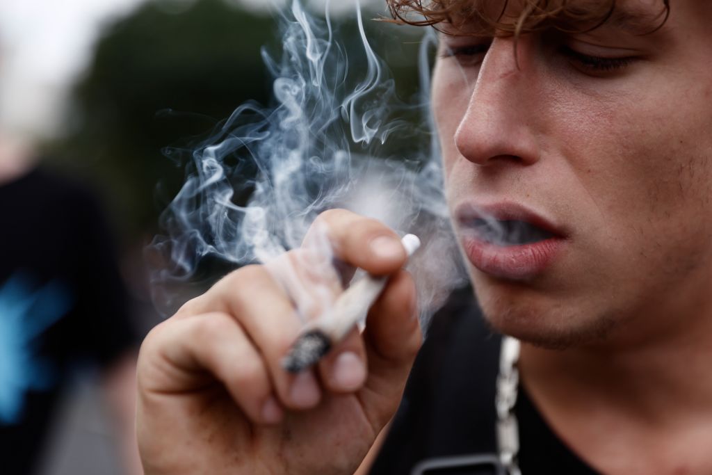 An participant smokes as activists demonstrating for the legalisation of marijuana march in the annual Hemp Parade (Hanfparade) on August 13, 2022 in Berlin, Germany.