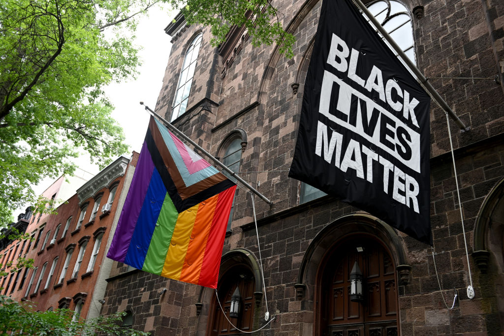 A progress pride flag and a Black Lives Matter flag are displayed outside a church on June 13, 2021 in the Brooklyn Borough of New York City.
