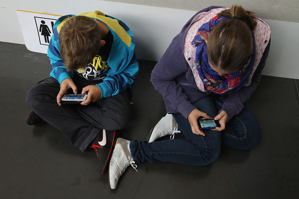 Children play video games on smartphones while attending a public event on September 22, 2012 in Ruesselsheim, Germany.