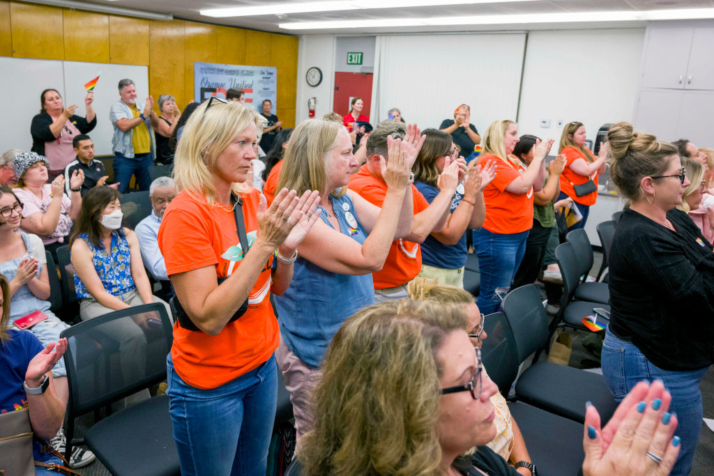 People opposing the proposed policy give board member Kris Erickson as standing ovation after she eloquently spoke out against the proposal during a meeting of the Orange Unified School District in Orange on Thursday, August 17, 2023 to consider adopting a policy that would require the school to notify parents that their child is transgender.